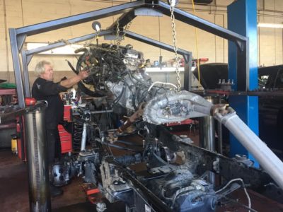 Engine removal of a vehicle with a Whitney Auto tech inspecting it