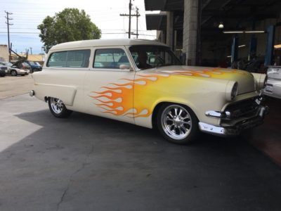 Classic car with a fire decal coming into our shop
